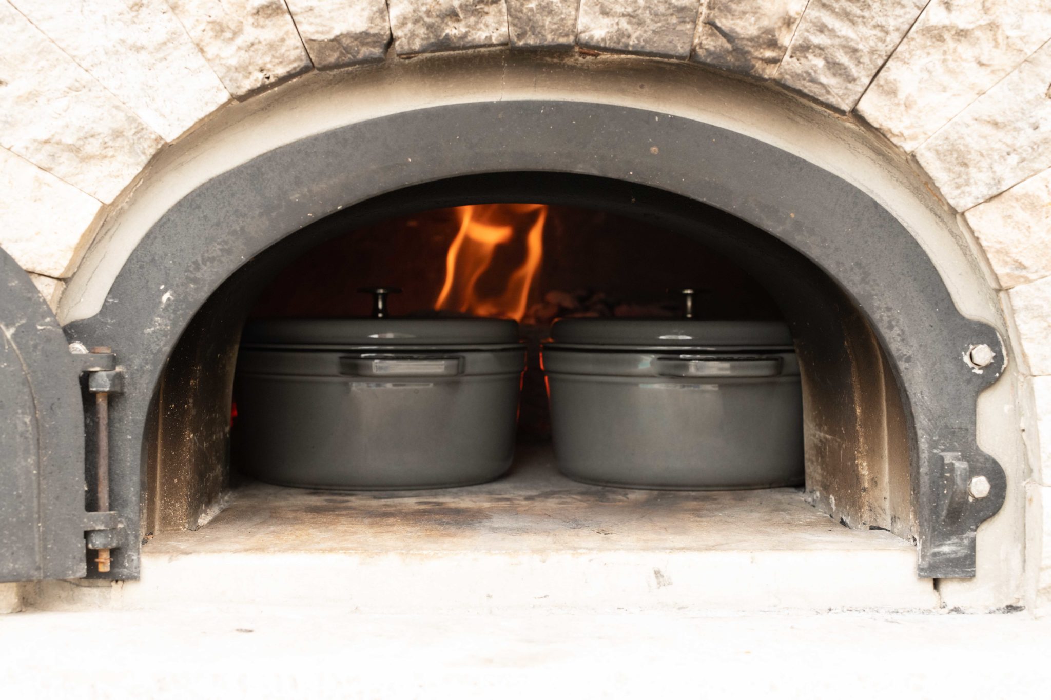 Bread Baking Inside Dutch Ovens in a Wood-Fired Oven.