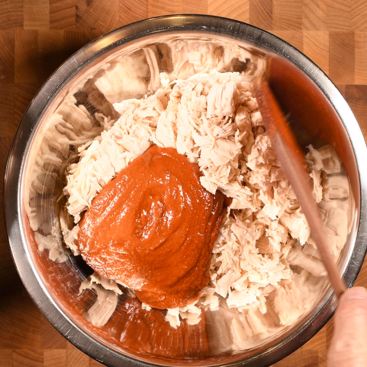 Add some of the birria sauce to the shredded chicken.