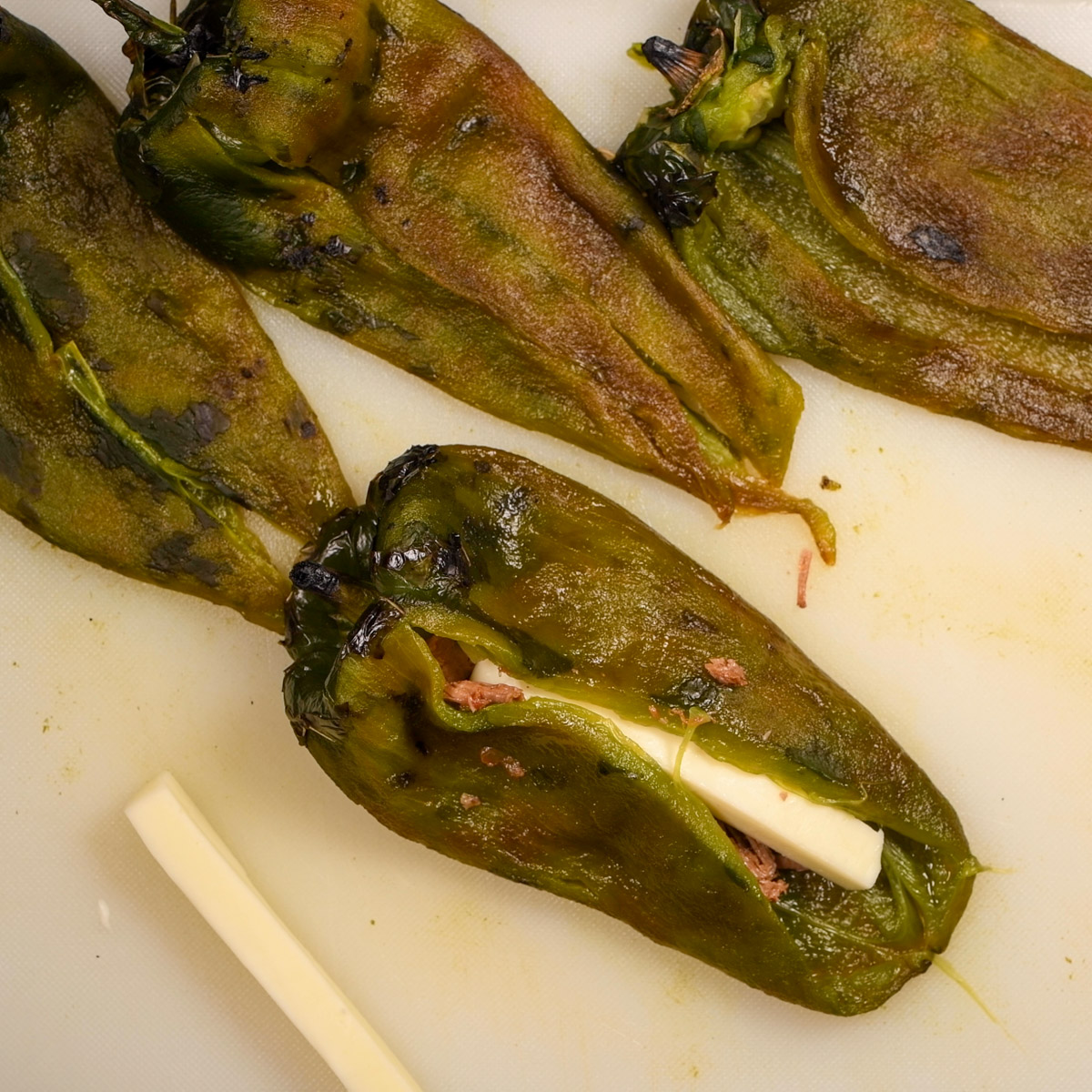 Add two strips of cheese to each poblano pepper.