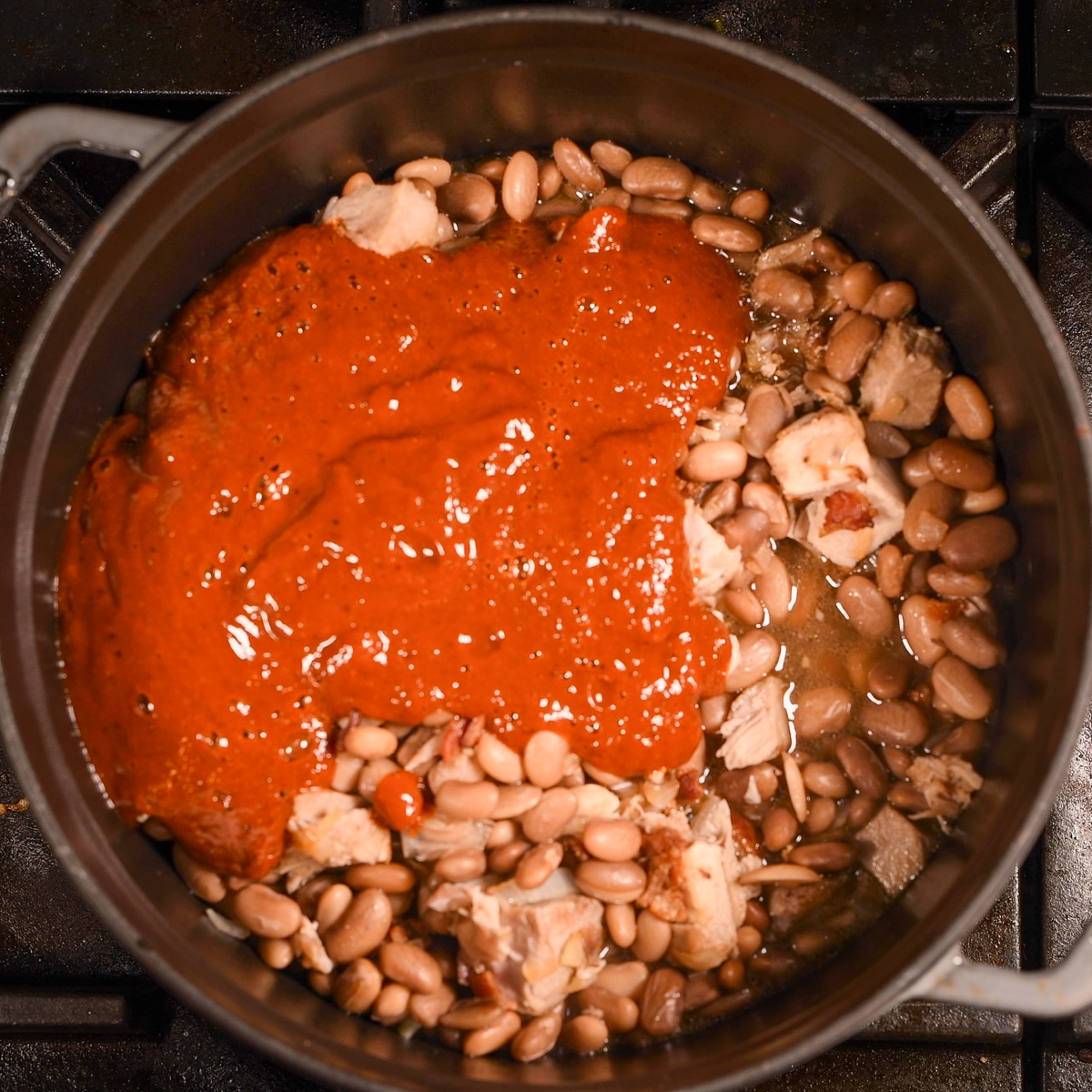 Add sauce to beans and carnitas.