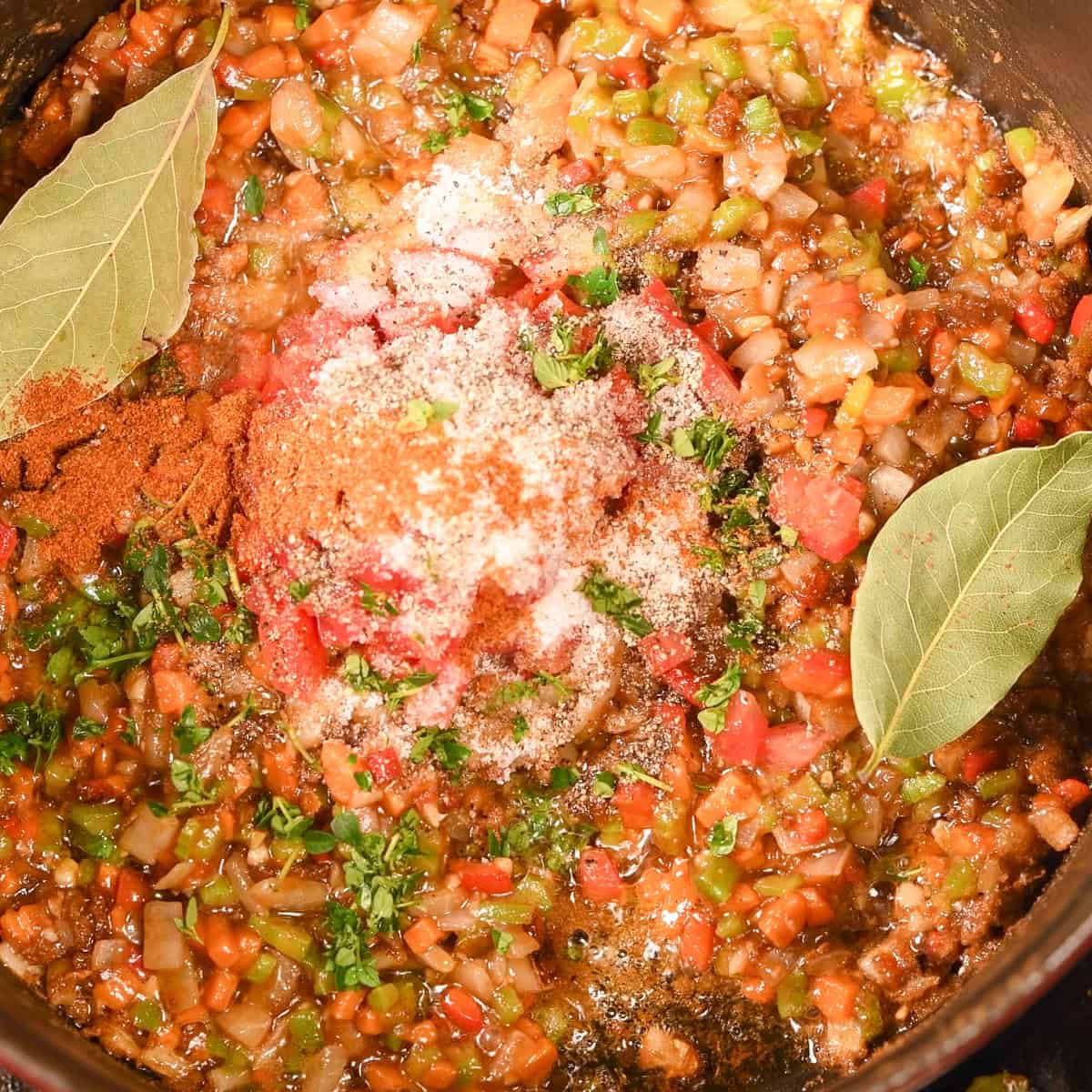 Add the tomatoes, salt, black pepper, thyme, cayenne pepper and bay leaves and stir.
