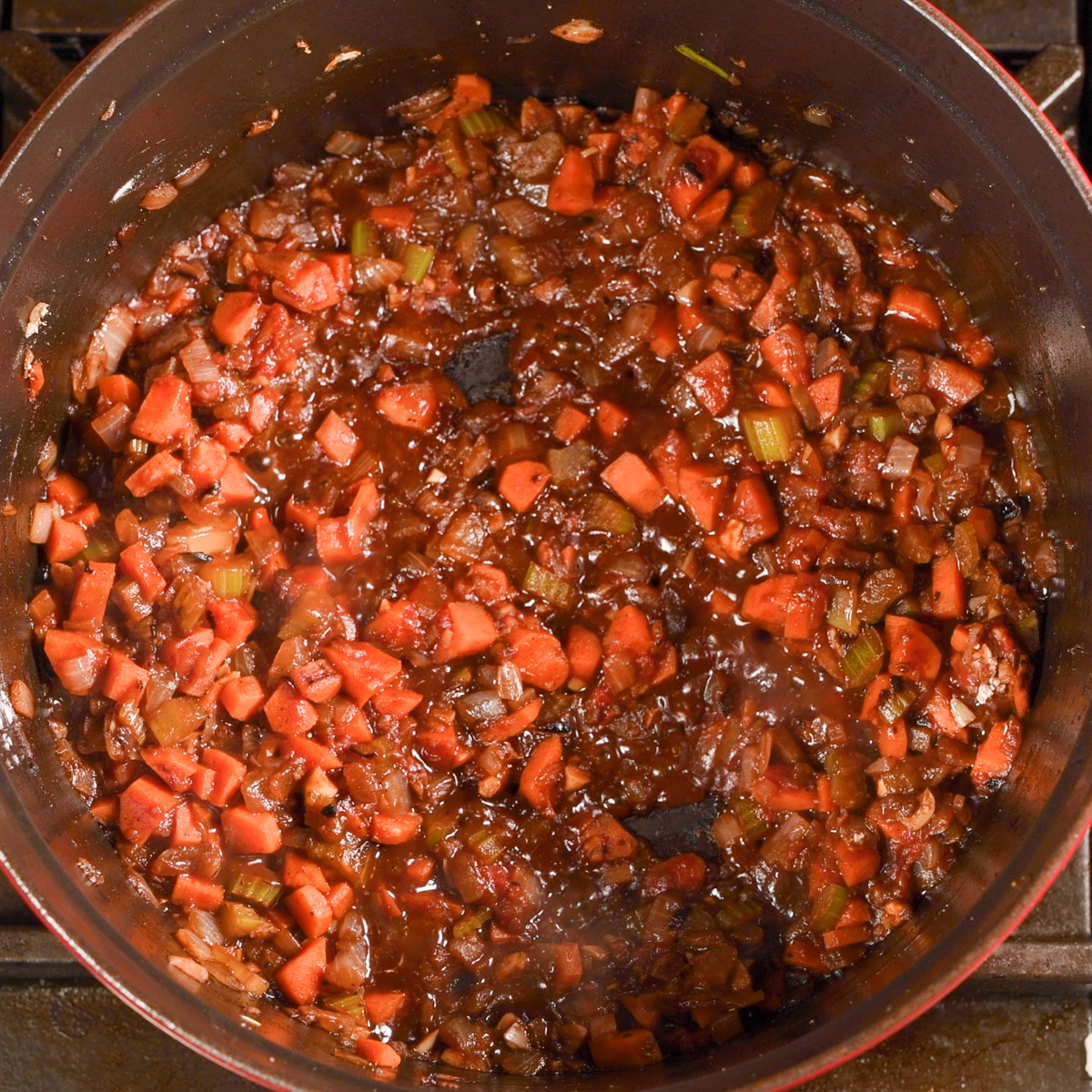 Add tomato paste to the softened vegetables.