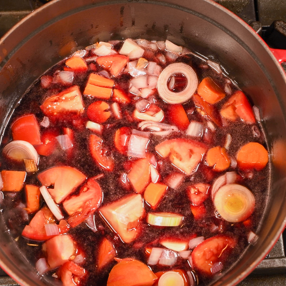 Add red wine to sauteed vegetables.