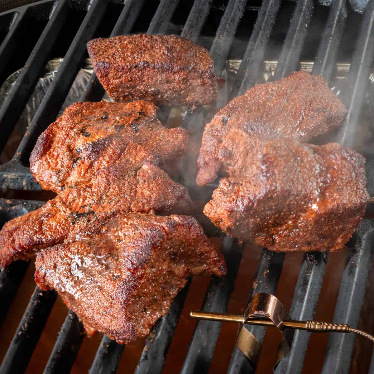 Brisket point pieces seasoned with dry rub and in the smoker.