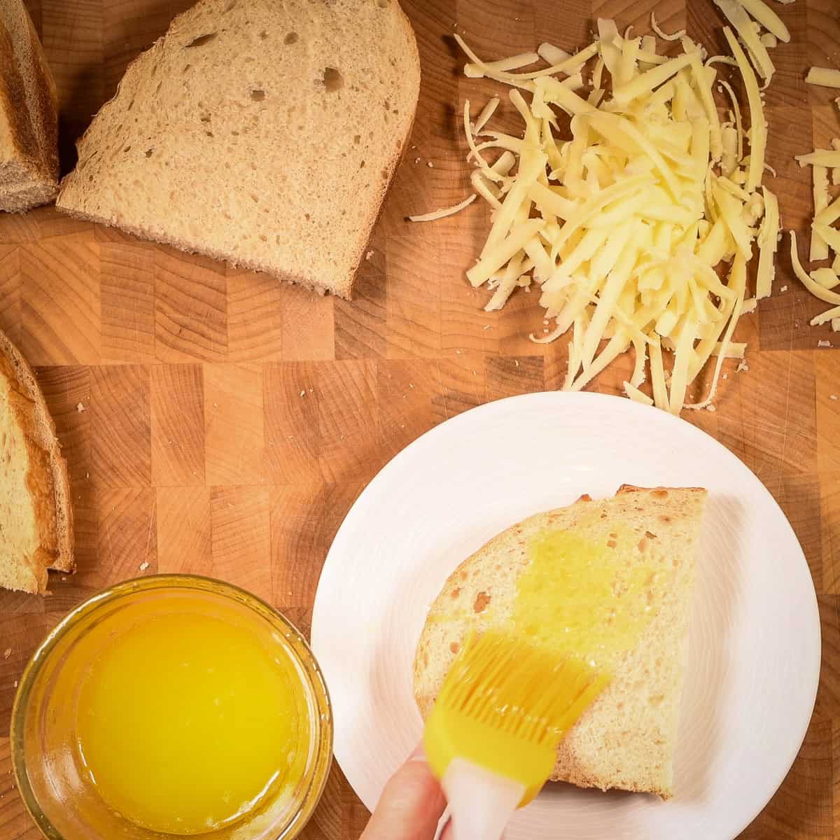 Butter both sides of thick cut sourdough bread.