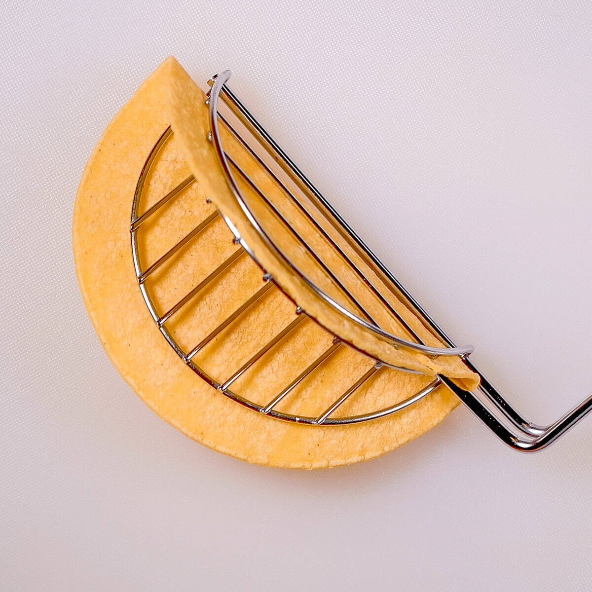 Place a corn tortilla in taco tongs.