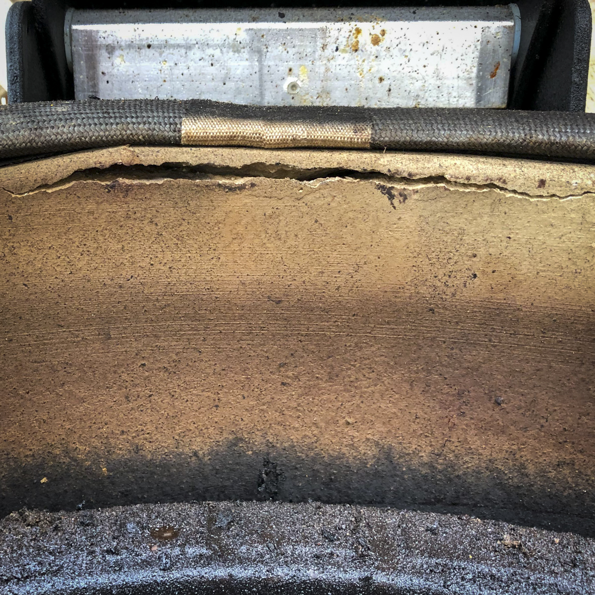 Cracks in the base of a Kamado Joe near the hinge.