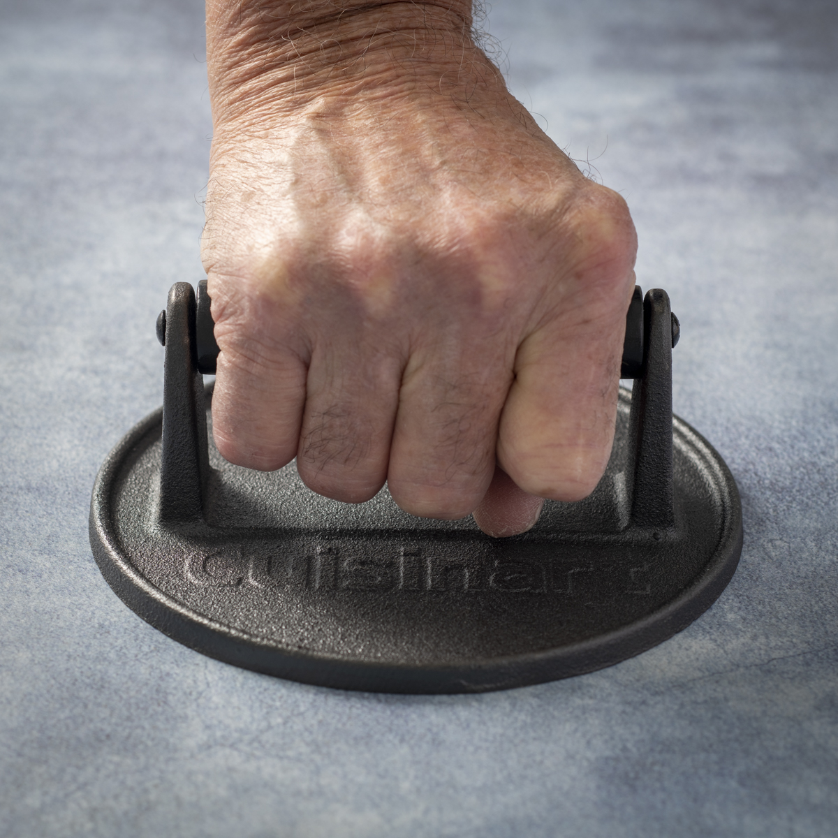 The Cuisinart cast-iron burger press has 4.25 inches internal handle clearance.