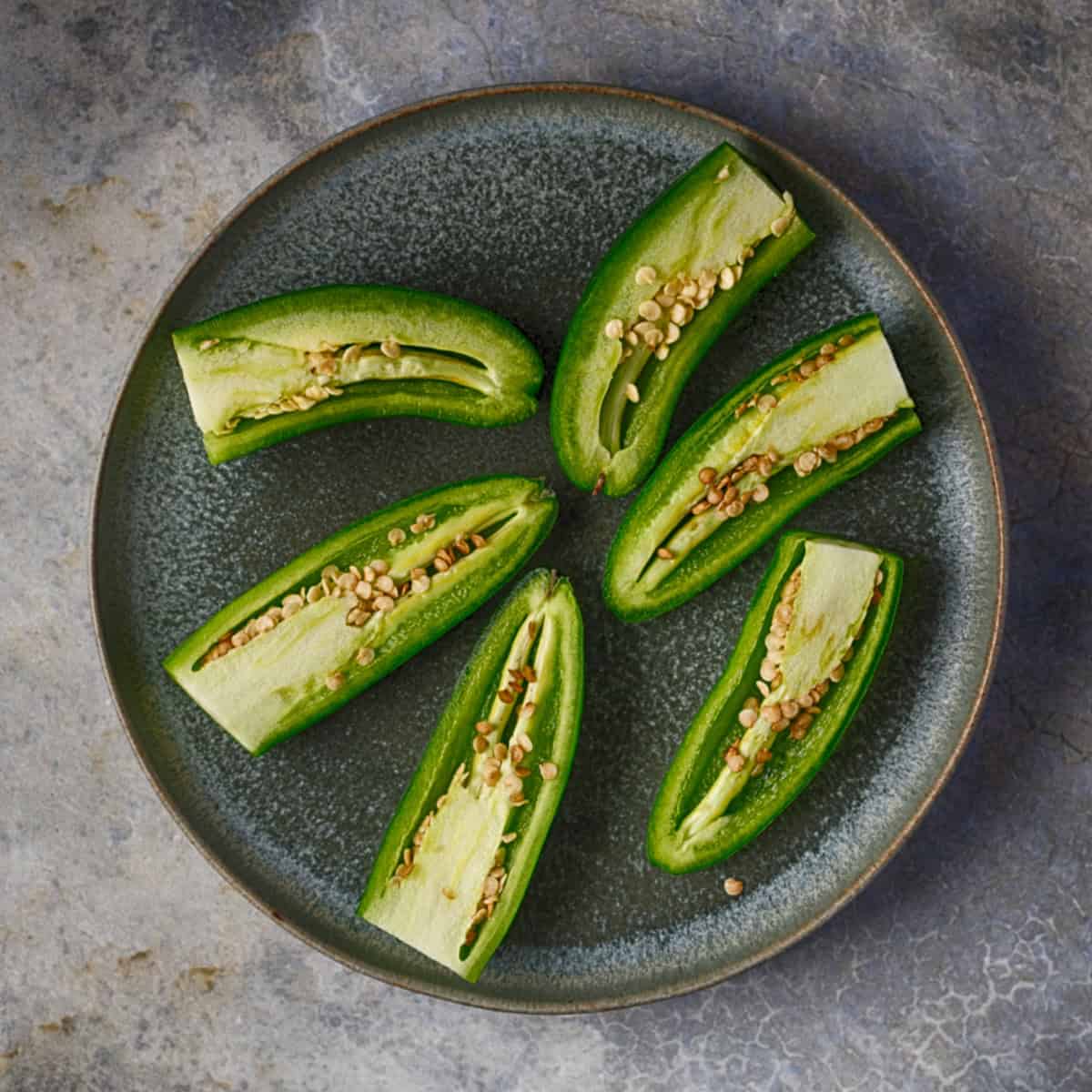 Cut jalapeno peppers in half.