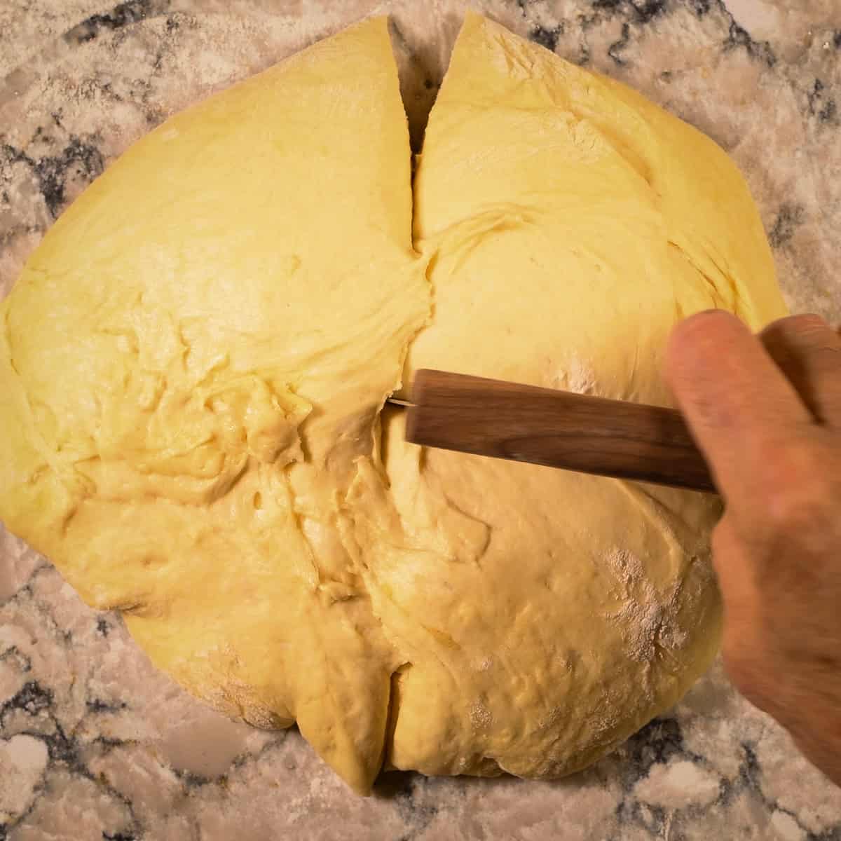 Cut the rested brioche dough into 8 equal pieces.