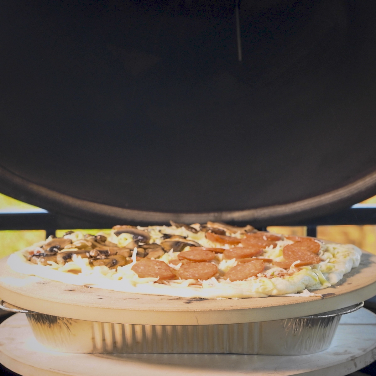 Elevated pizza stone inside a Kamado Joe.
