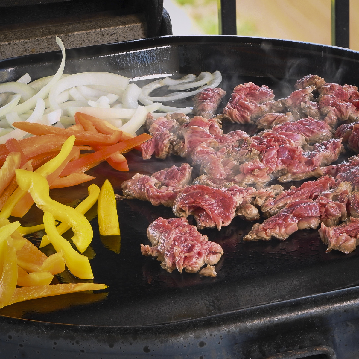 Fajitas cooking on the griddle.