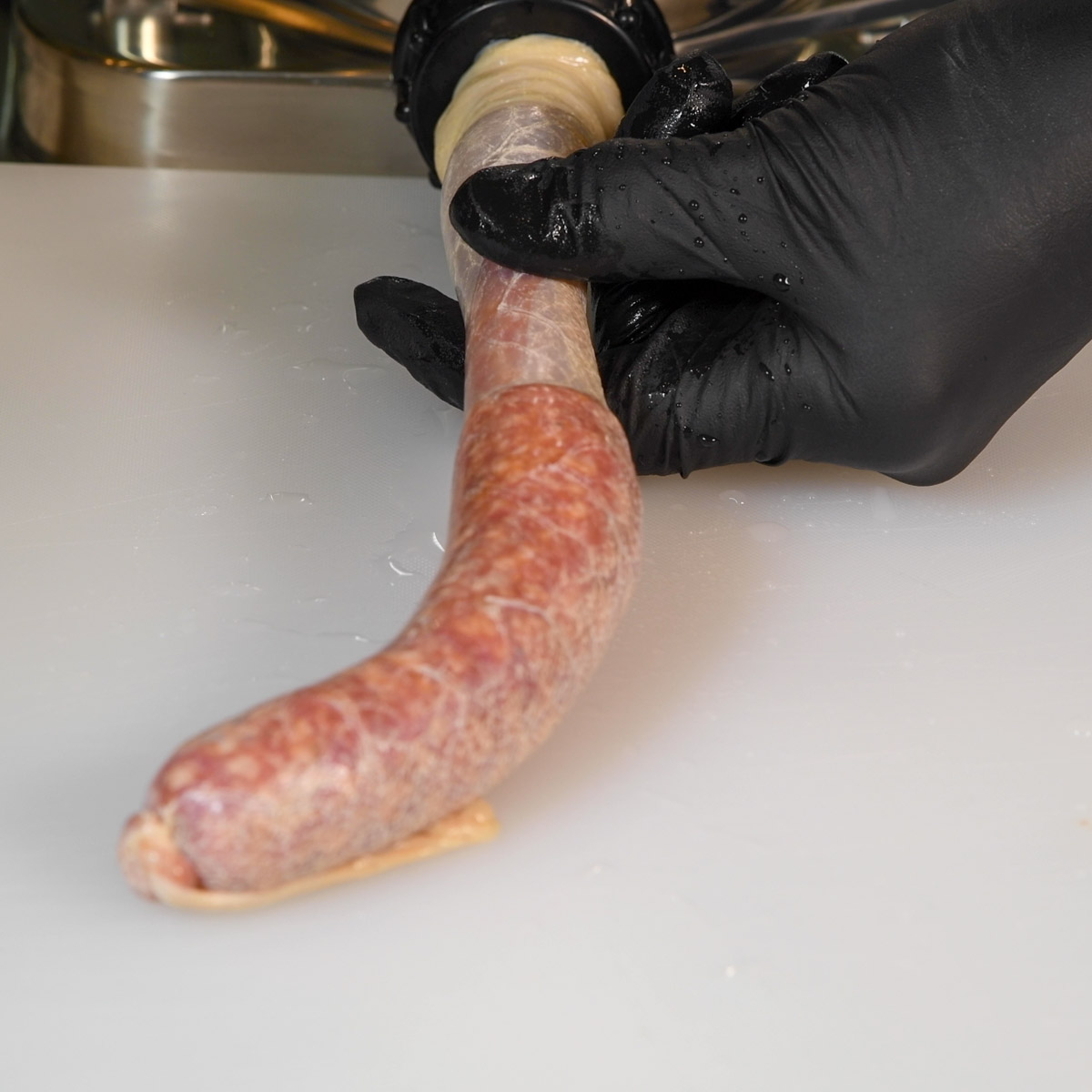 Stuff the natural casings using the sausage stuffer.