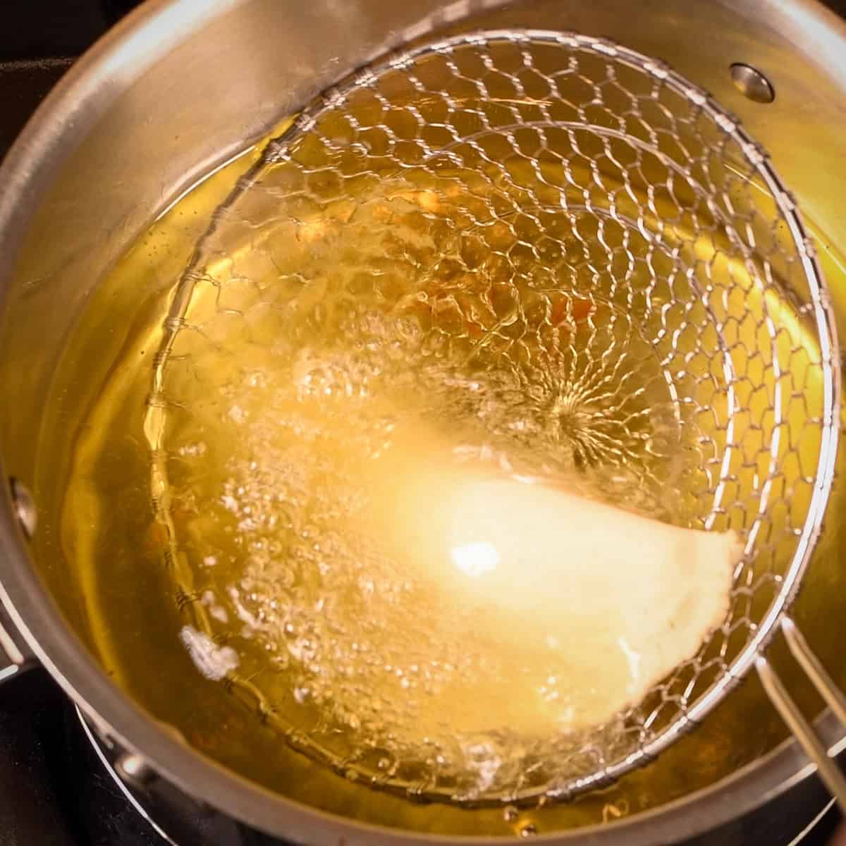 Cook the empanada in hot oil for 4 minutes per side.