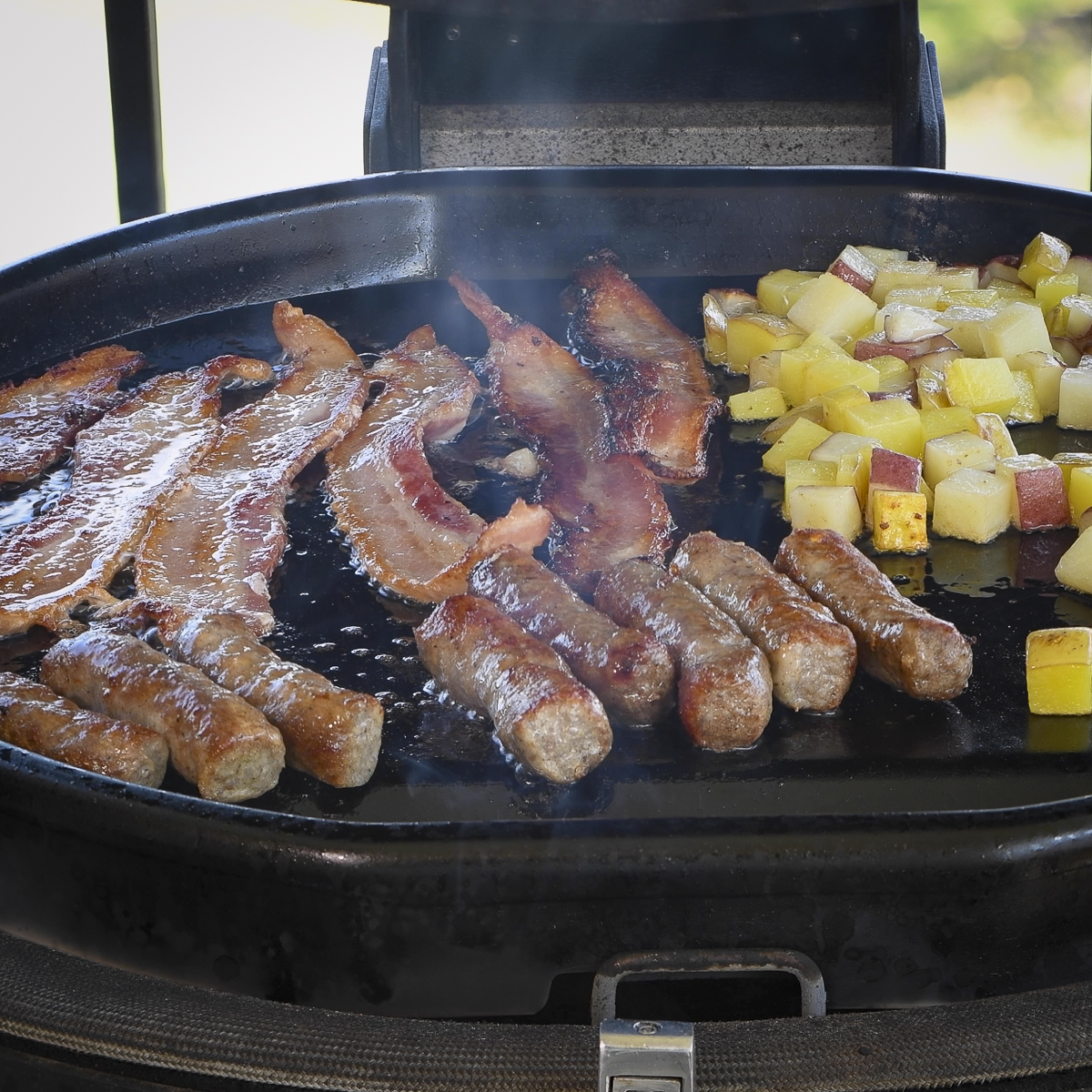 Bacon, sausage and potatoes on the griddle.