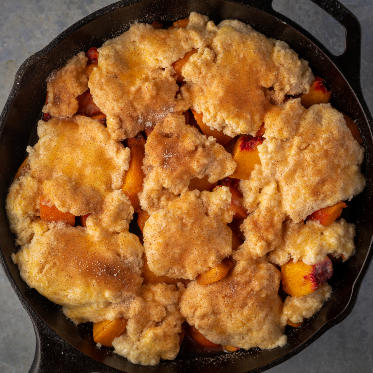 Peach cobbler with biscuit dough on top.