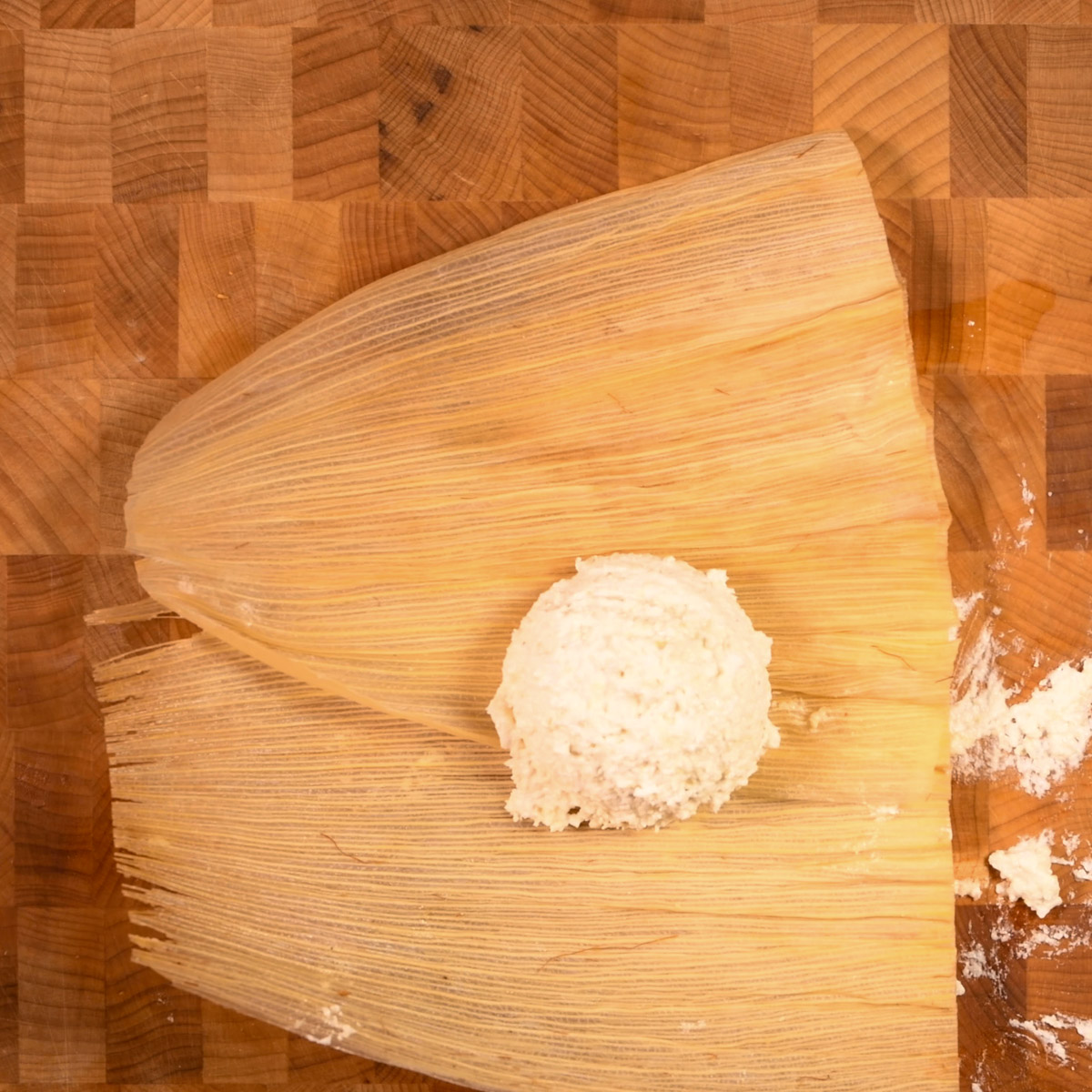 Place a ball of masa on two overlapping corn husks.