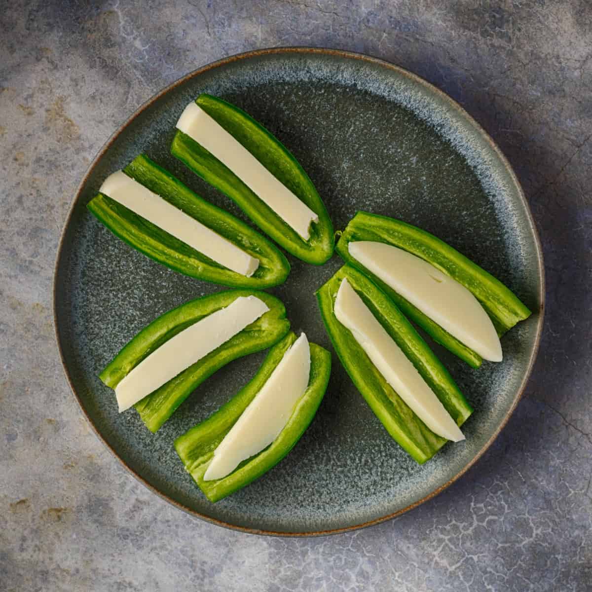 Place a piece of cheese inside each jalapeno half.