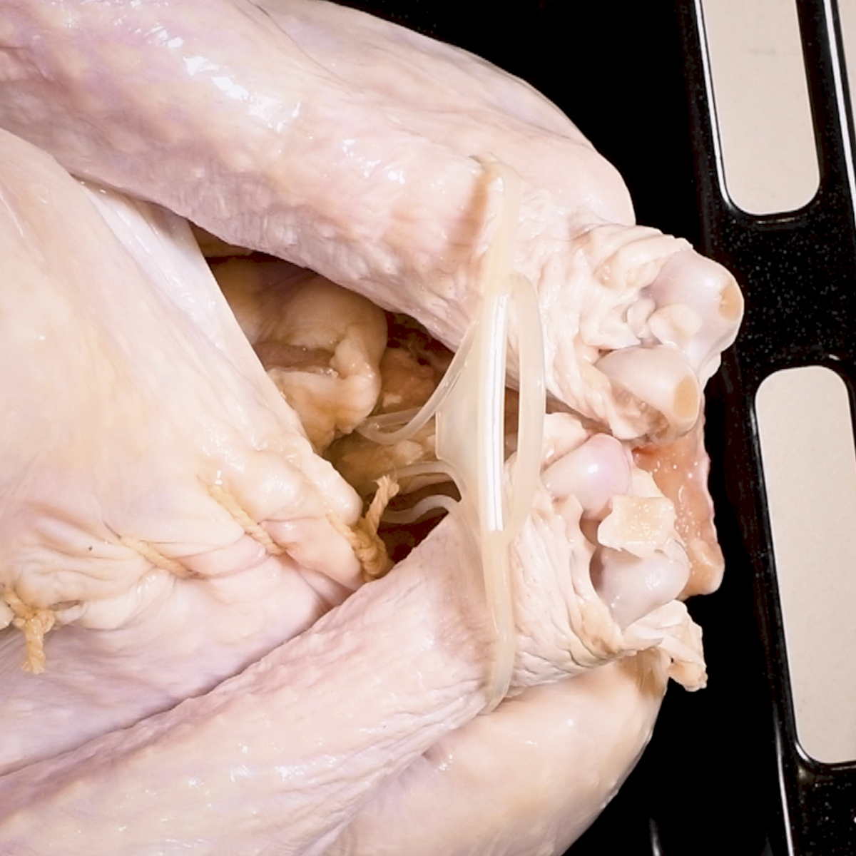 Remove the plastic leg tie before cooking on a rotisserie.