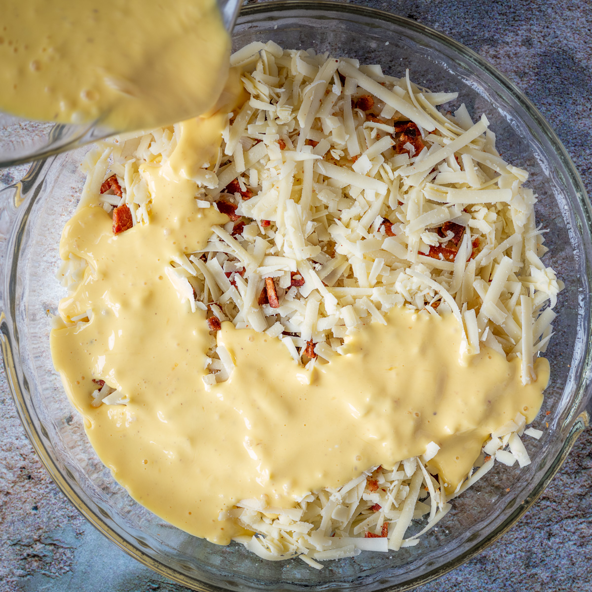 Pour egg mixture over the cheese, bacon and onion.