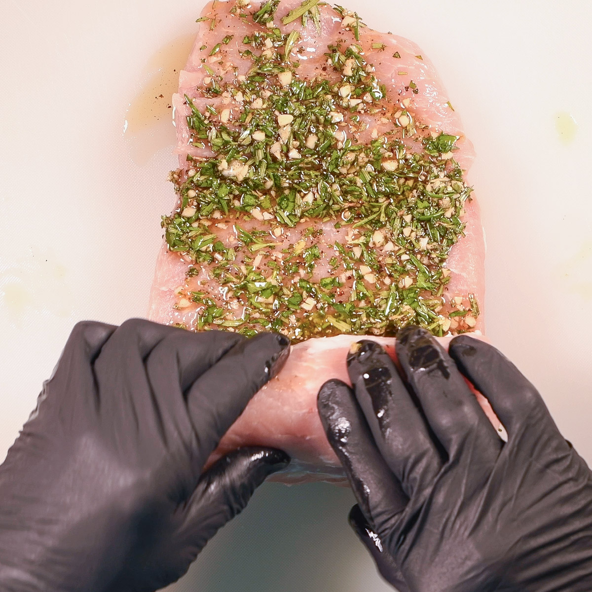 Starting with a short side, roll up the roast with the herbs inside.