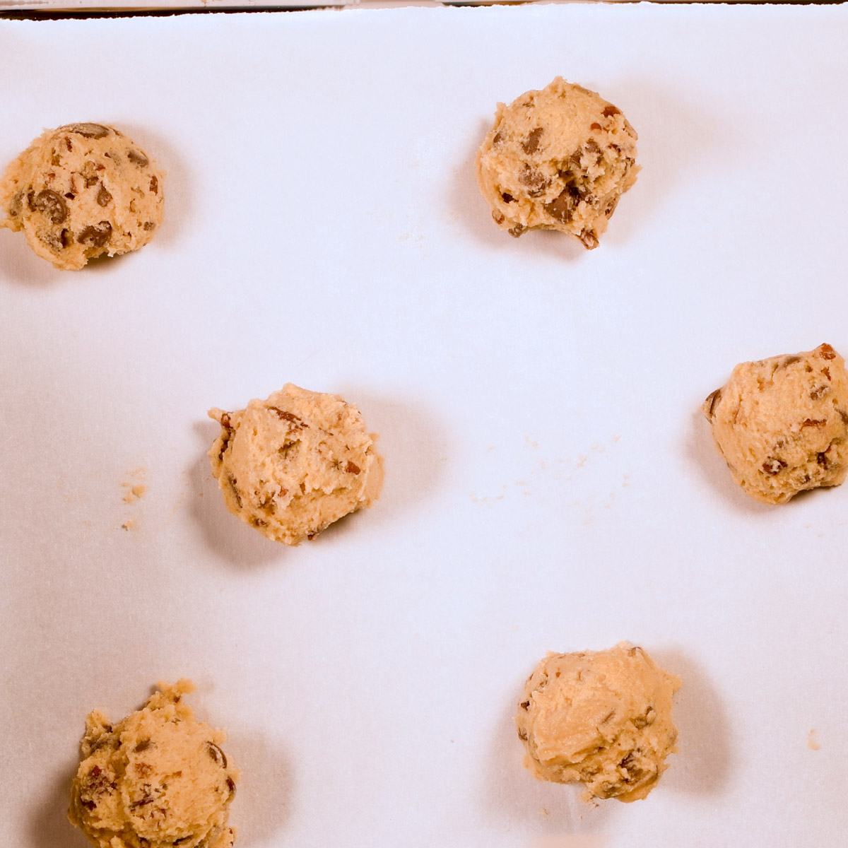 Add scoops of cookie dough to a parchment-lined baking sheet.