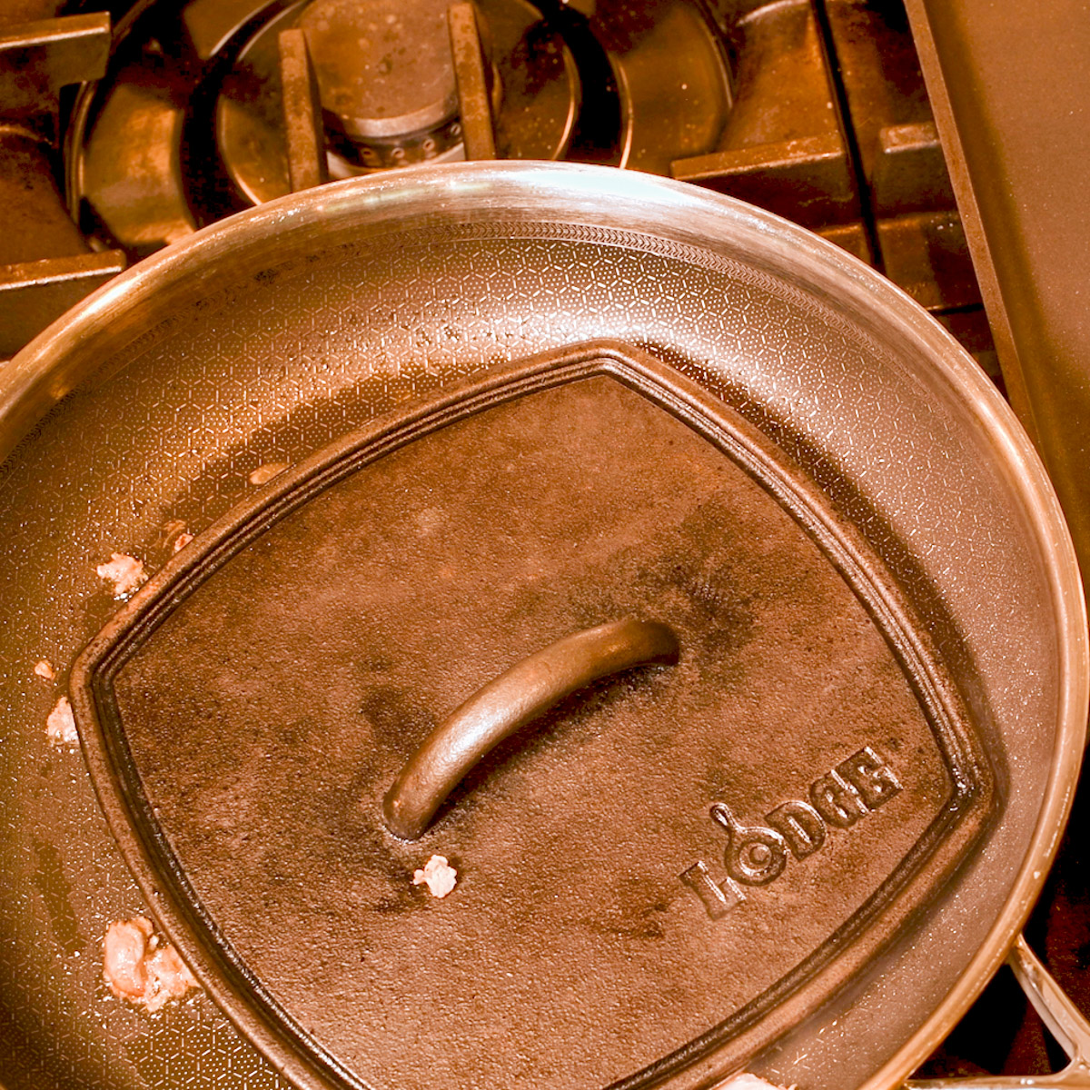 Sear the carnitas meat in a hot skillet with a cast iron press.