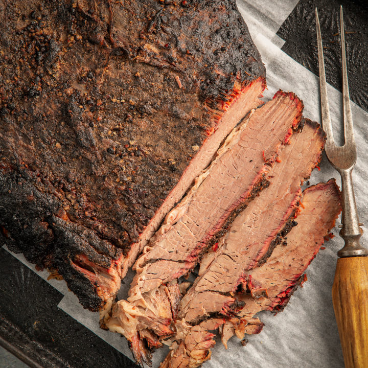 Sliced brisket showing liquid released onto the cutting board.
