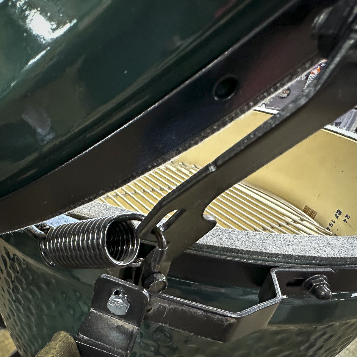 The dome on a Big Green Egg is raised with a spring assist system.