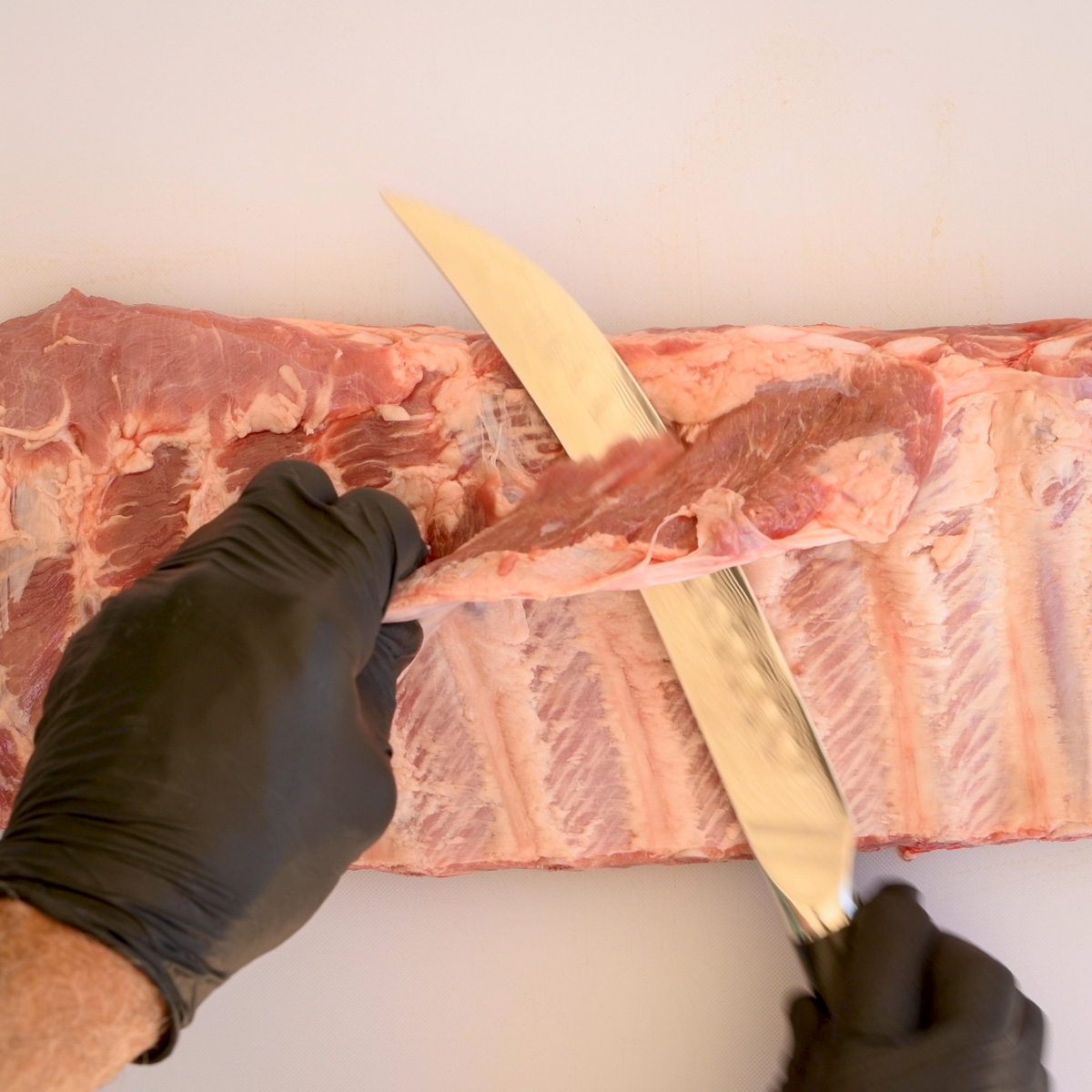 Trim the flap of meat from the back of the ribs.